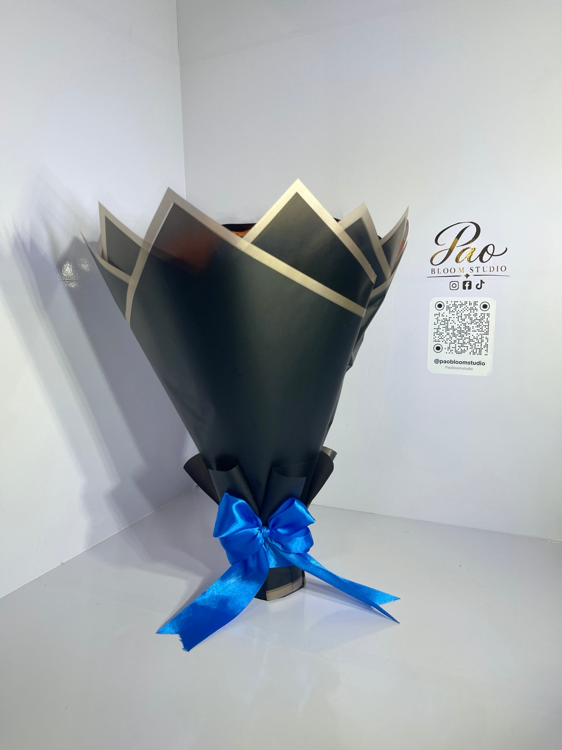 Black and gold bouquet wrapping with blue satin bow