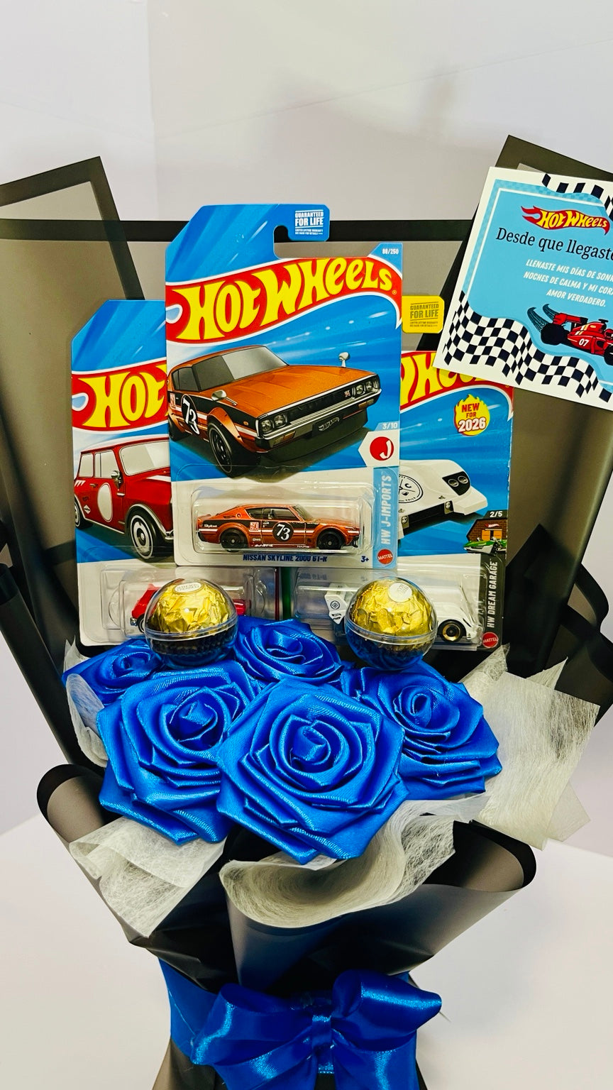Close-up of collectible cars, chocolates and blue satin roses