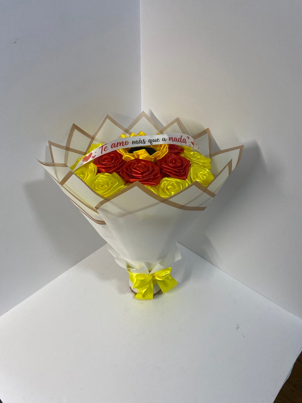 Red and yellow satin rose bouquet with sunflower and cream wrapping, front view
