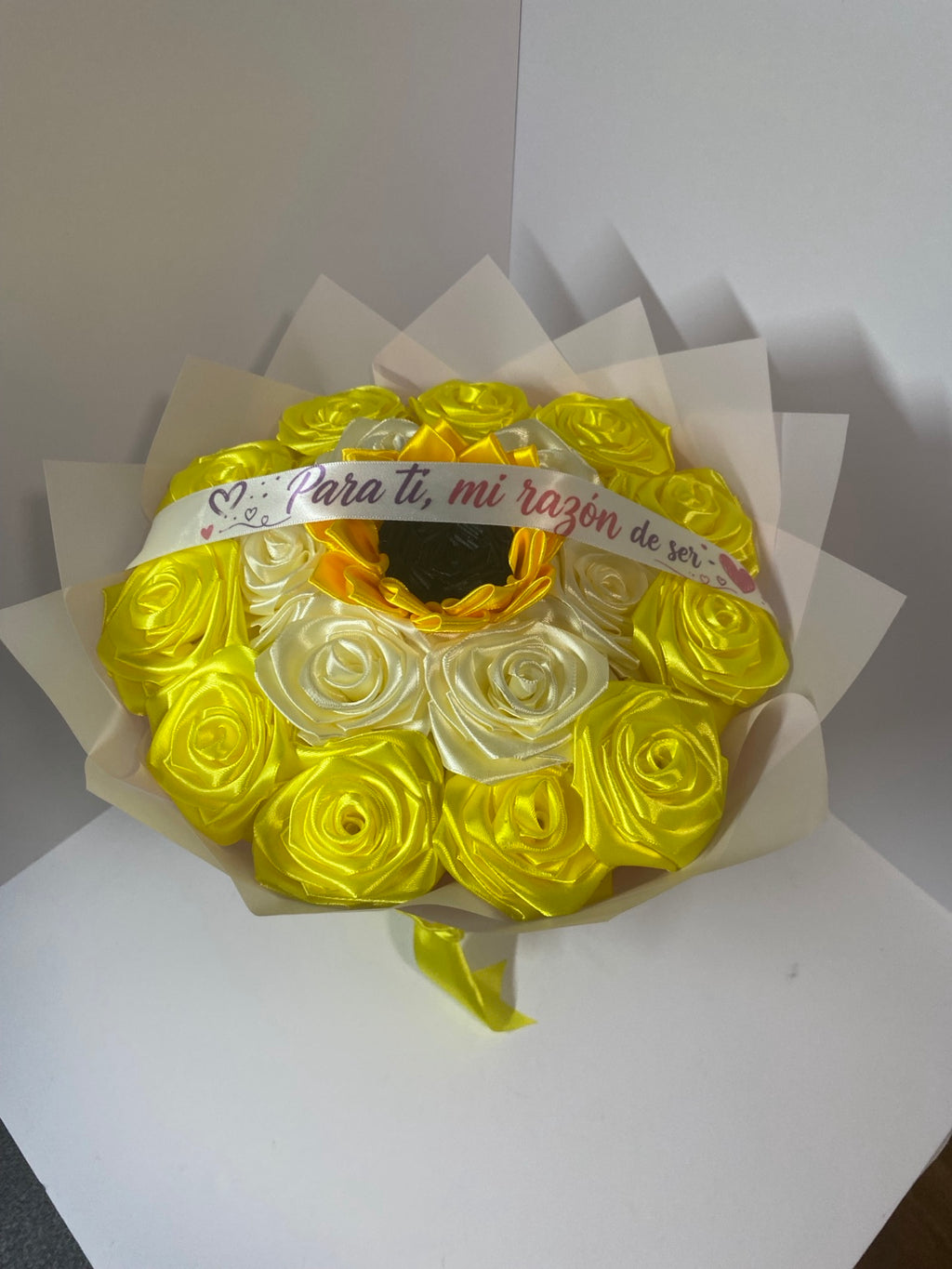 Golden yellow and ivory satin rose bouquet with sunflower center, white Spanish message ribbon, and blush ivory wrapping paper