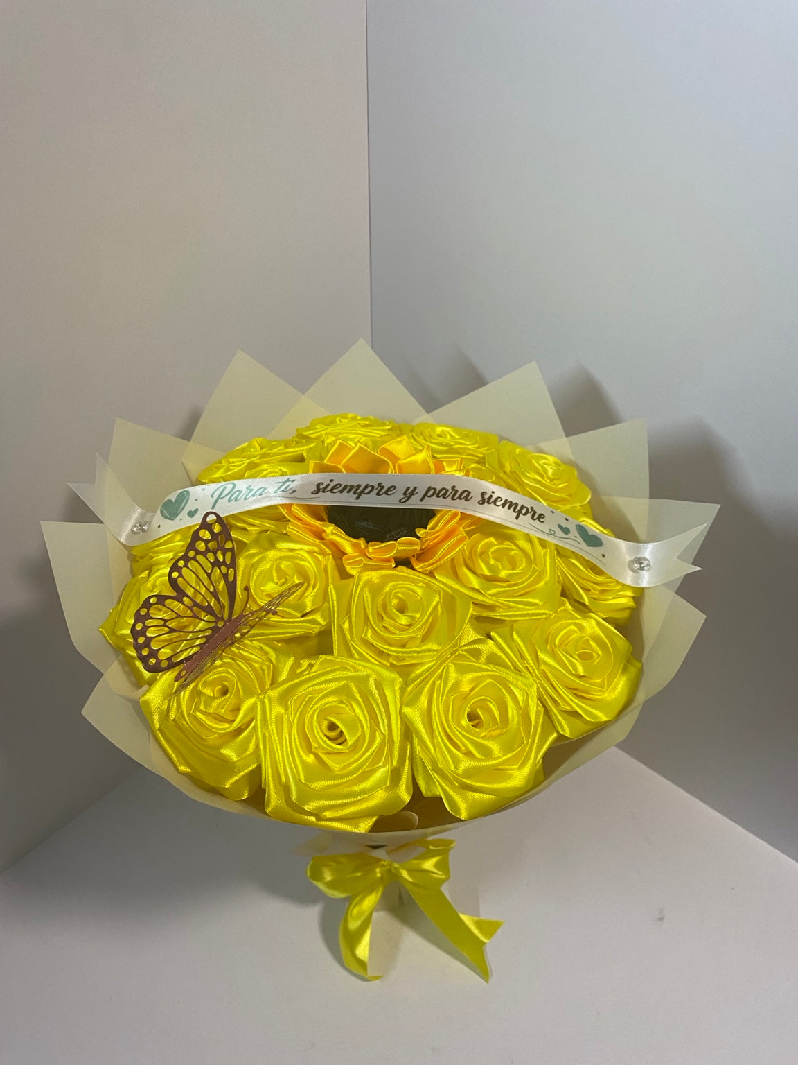 Golden satin rose bouquet with sunflower center, pink butterfly, white message ribbon, and ivory champagne wrapping paper