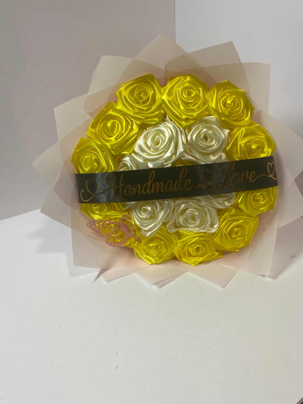 Front view of golden yellow and ivory satin rose bouquet with butterfly and black message ribbon