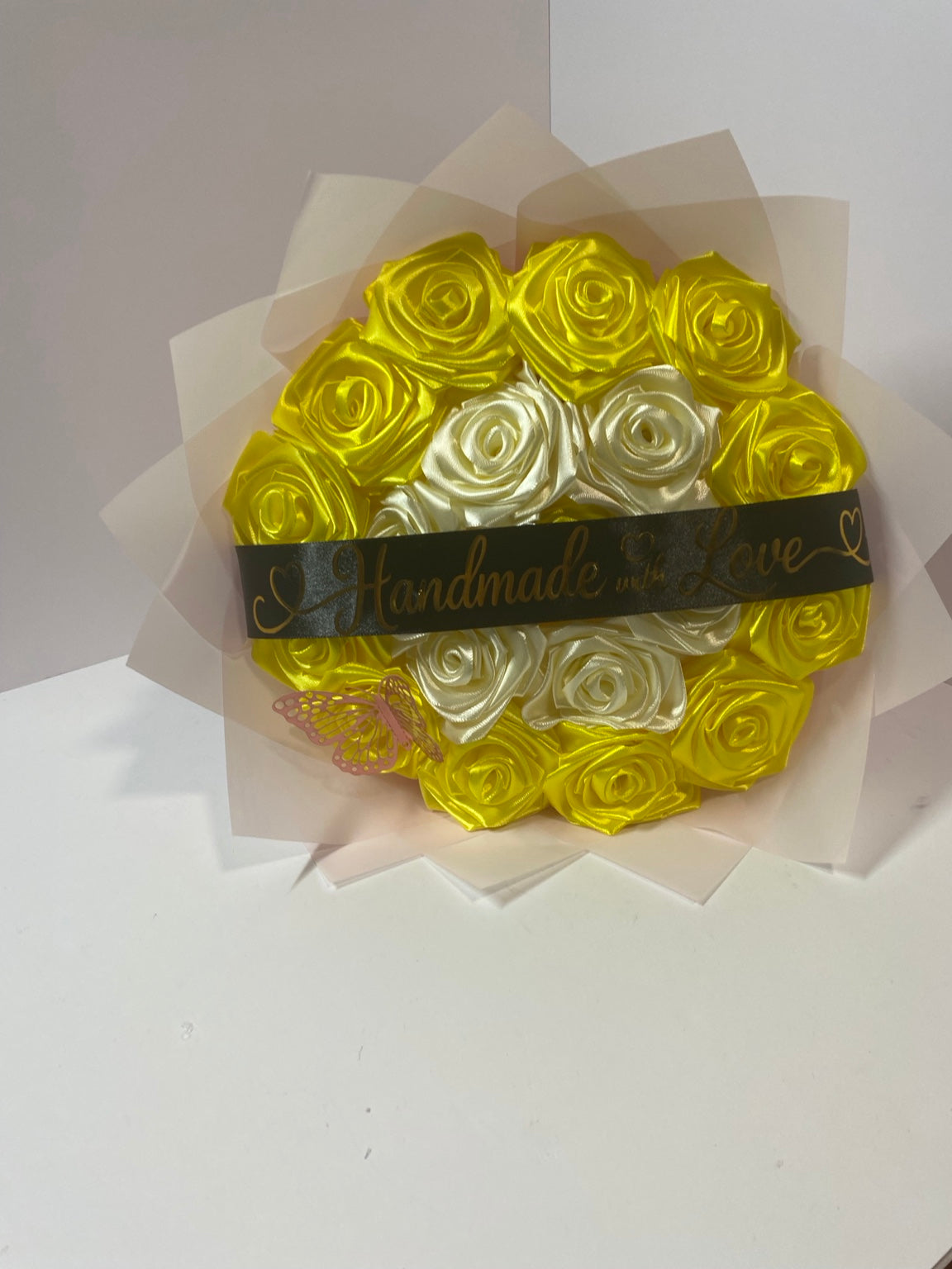 Front view of golden yellow and ivory satin rose bouquet with butterfly and black message ribbon
