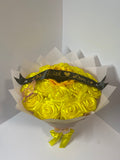 Golden satin rose bouquet with sunflower center, pink butterfly, black With Love ribbon, and soft blush wrapping paper