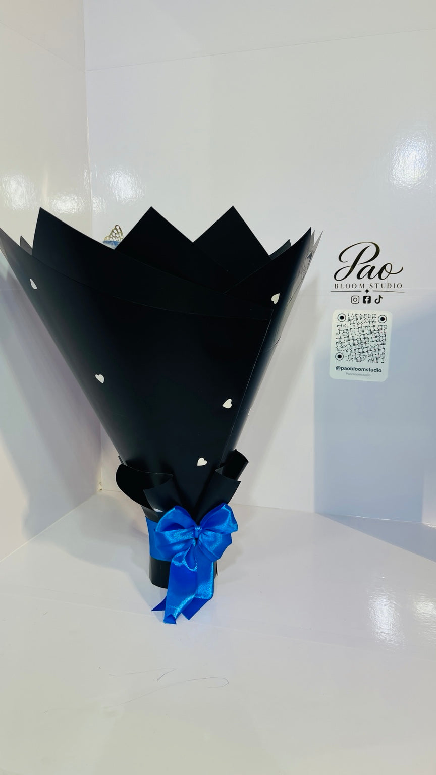 Black heart-pattern bouquet wrap with blue satin bow
