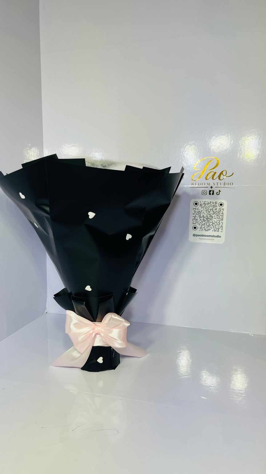 Black heart-pattern bouquet wrap with pink satin bow