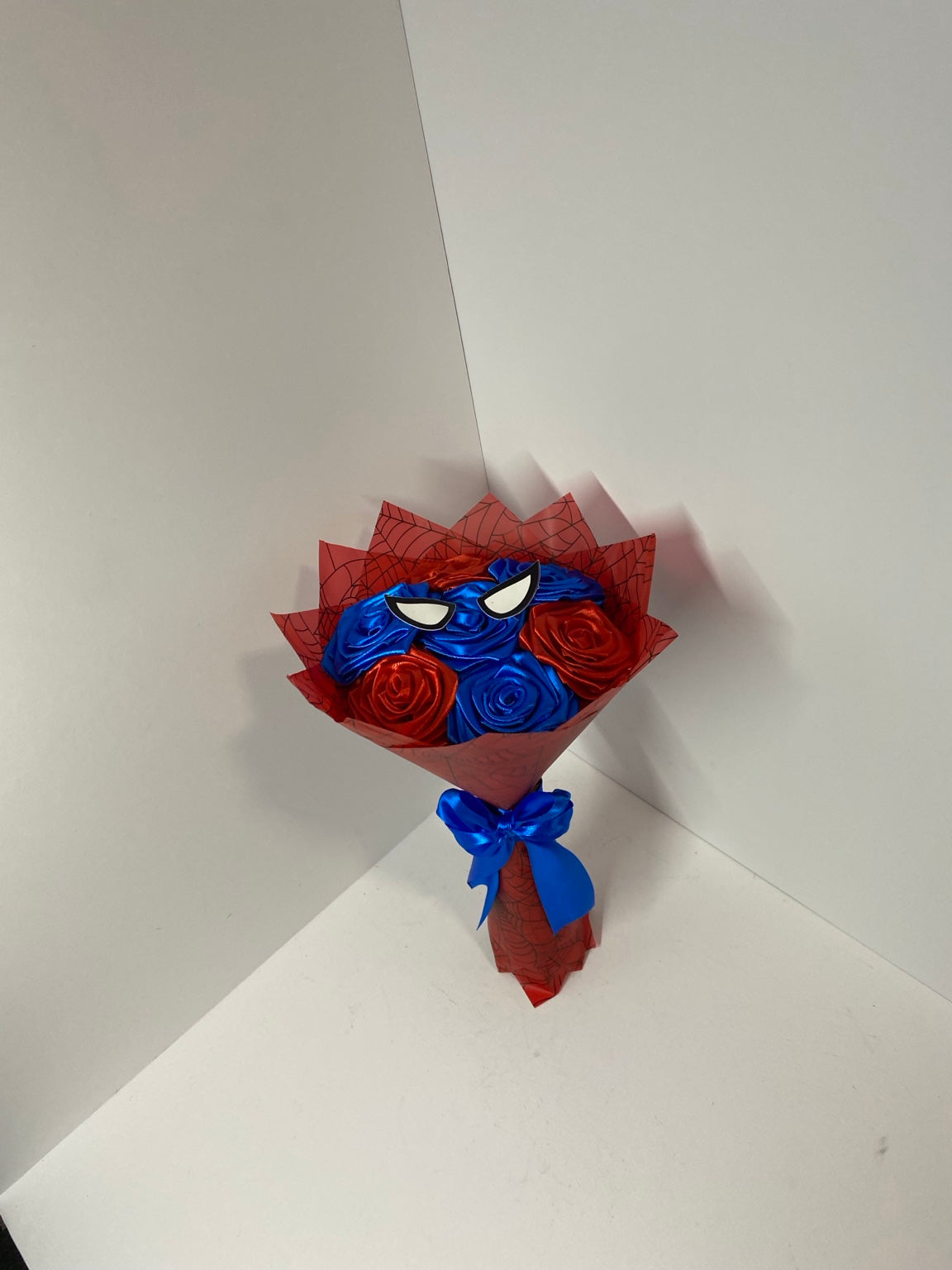 Detailed view of red and blue satin roses with black web wrap