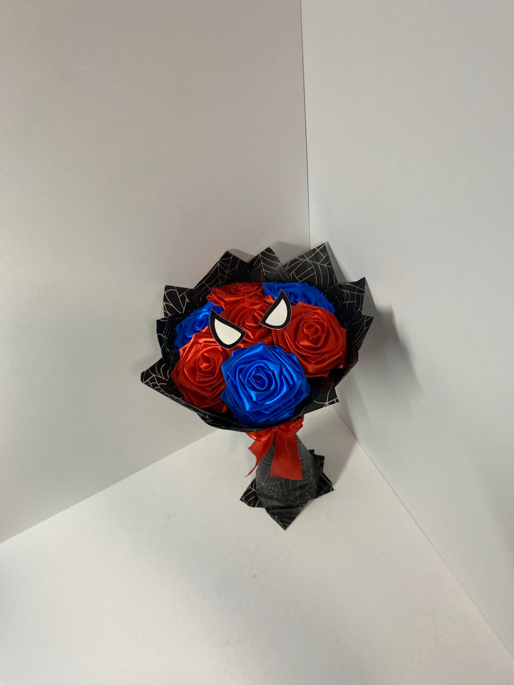 Mini red and blue satin rose bouquet with black web-pattern wrap
