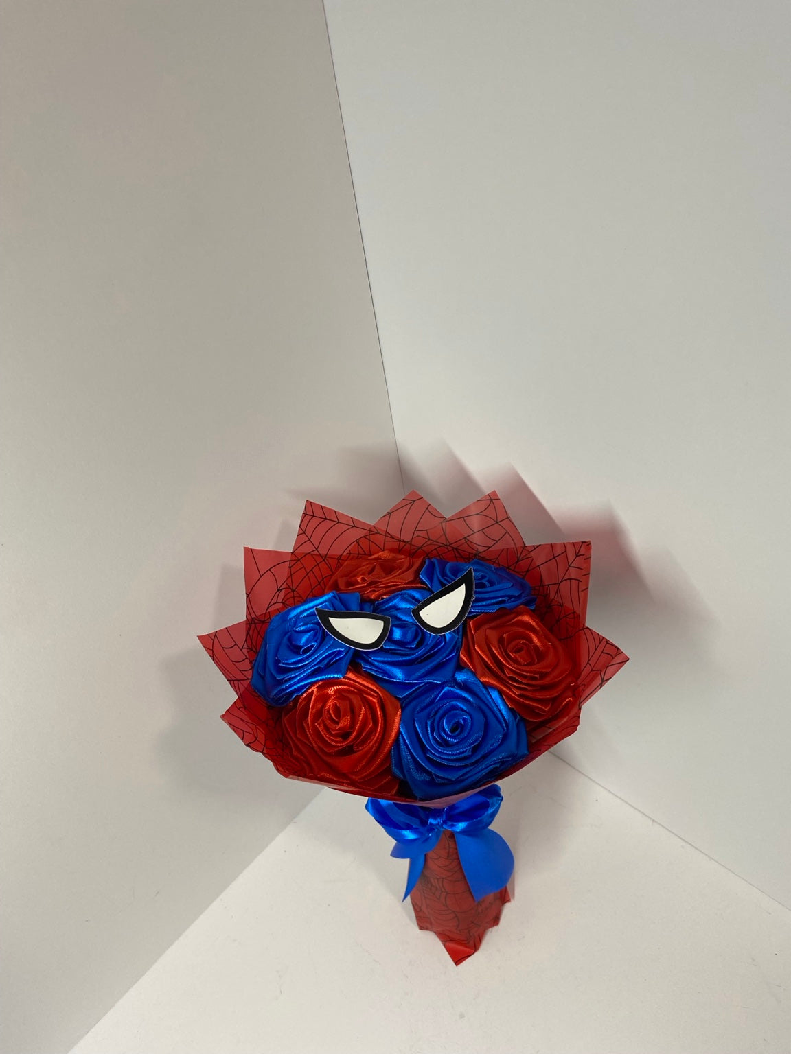 Close view of handmade satin roses and web-themed accents