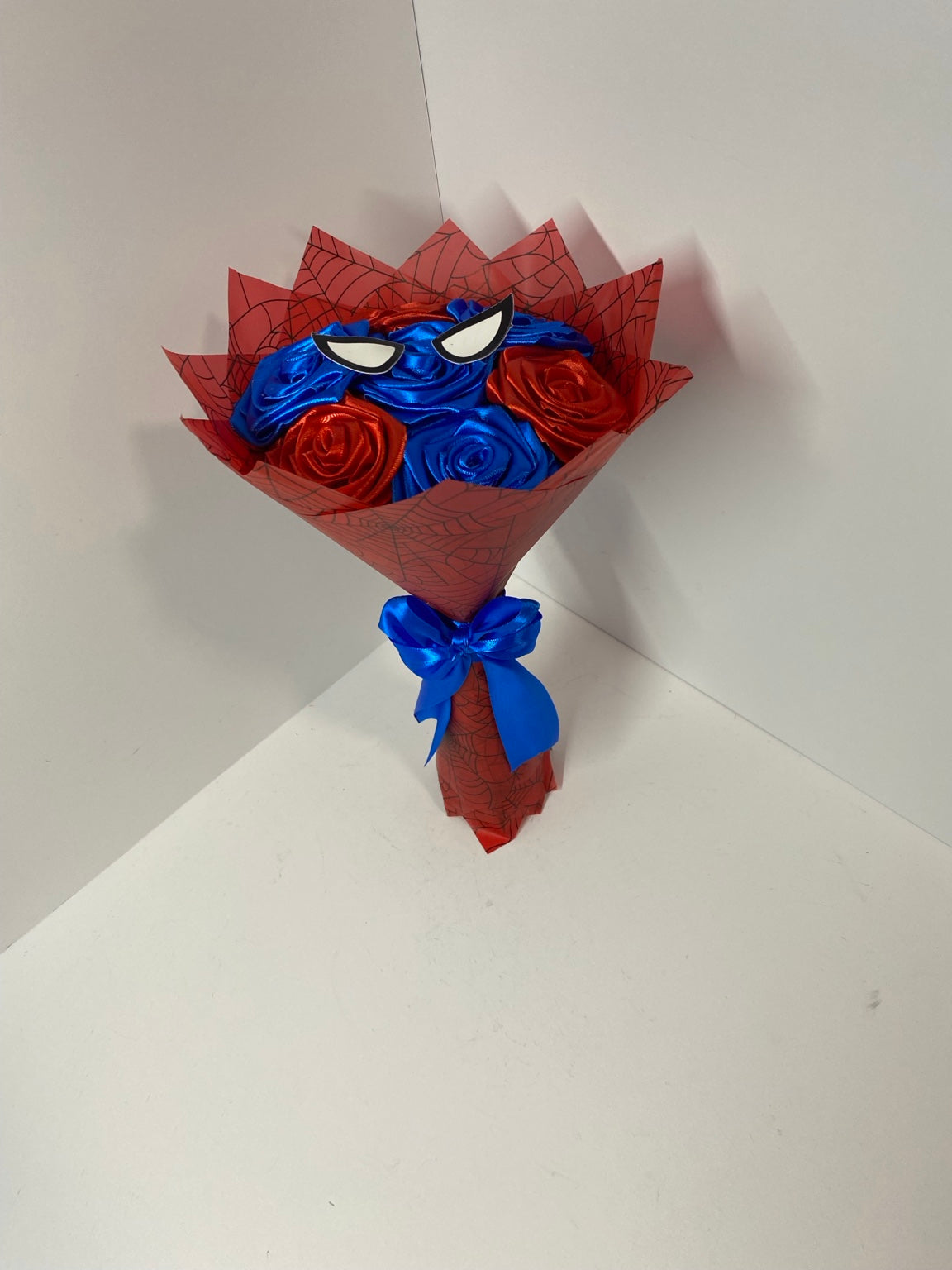 Mini red and blue satin rose bouquet with red web-pattern wrap