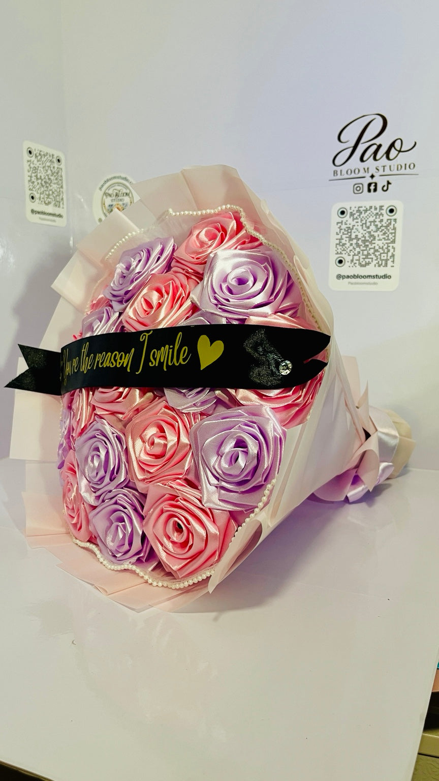 Angled view of pink and lavender satin ribbon rose bouquet