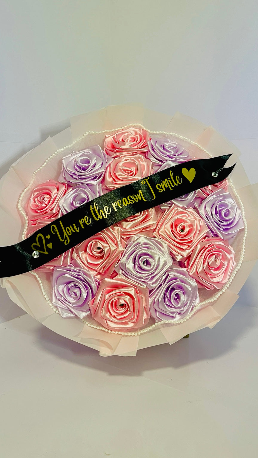 Pink and lavender handcrafted satin rose bouquet with personalized black ribbon