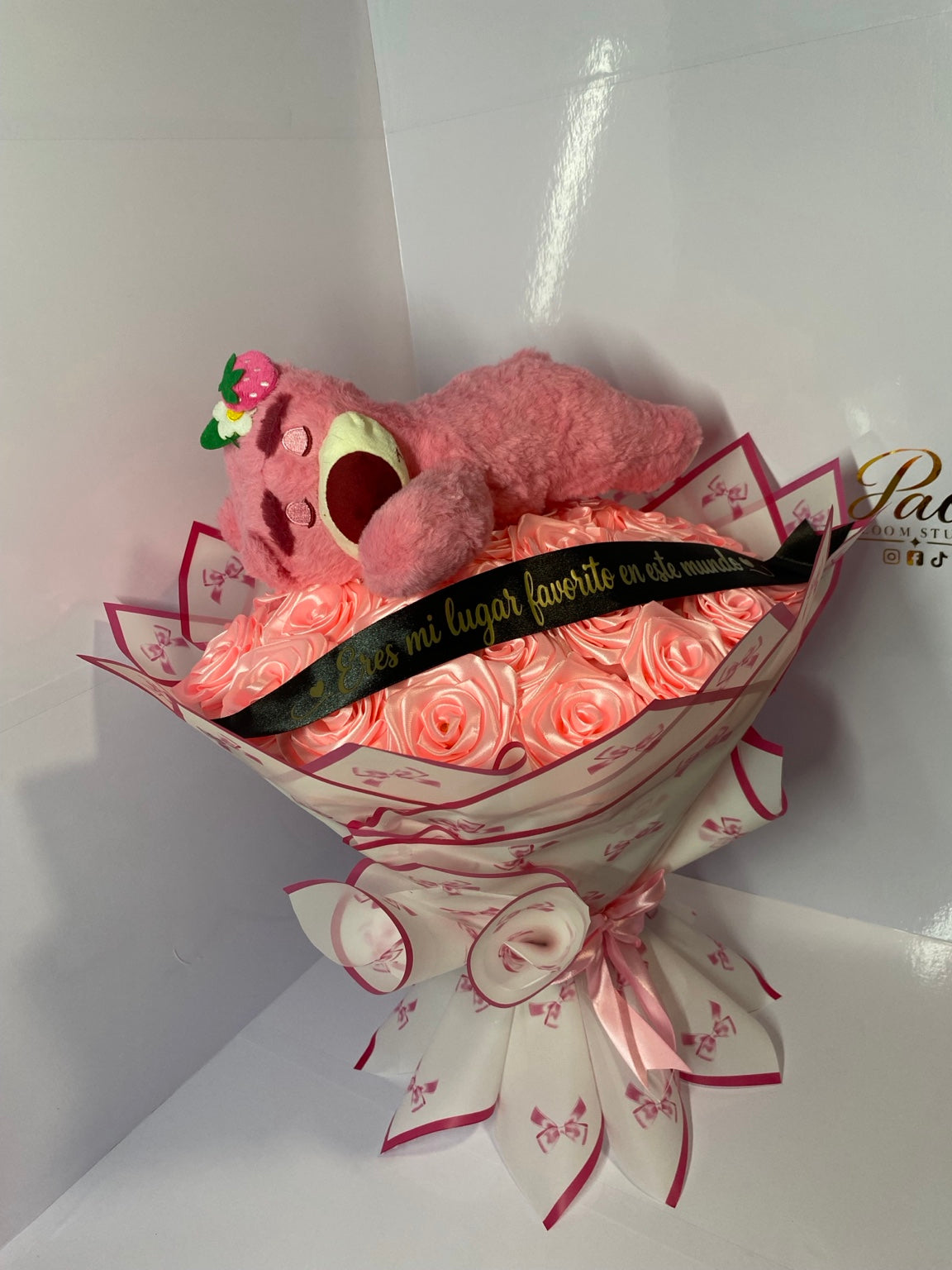 Detailed view of pink satin roses, plush bear and decorative wrapping