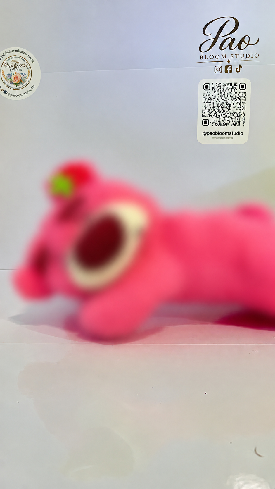 Pink strawberry bear plush with strong selective blur, view 1