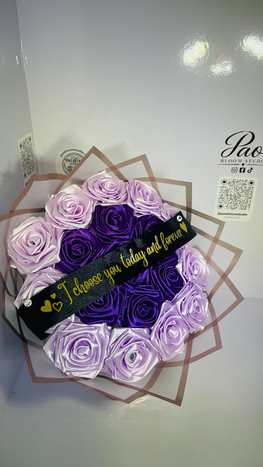 Top view of purple and lavender handmade satin roses with personalized ribbon